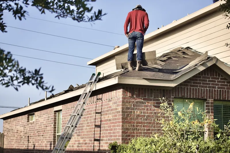 Professional roofer working on a residential roof in Breezewood